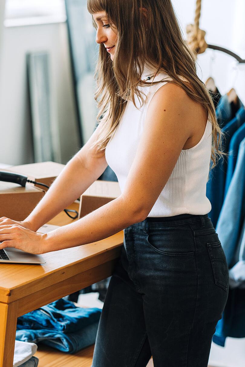 E-Commerce Situation mit prüfender Frau am Laptop